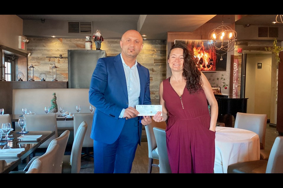 NewRoads Mazda general manager Curtis Biggs presents a cheque for $2,000 to Cachet Supper Club owner Jennifer McLachlan. 