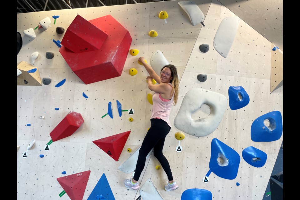 Emily Vincent, one of the owners of Reach Indoor Climbing, on the boulder climbing wall.