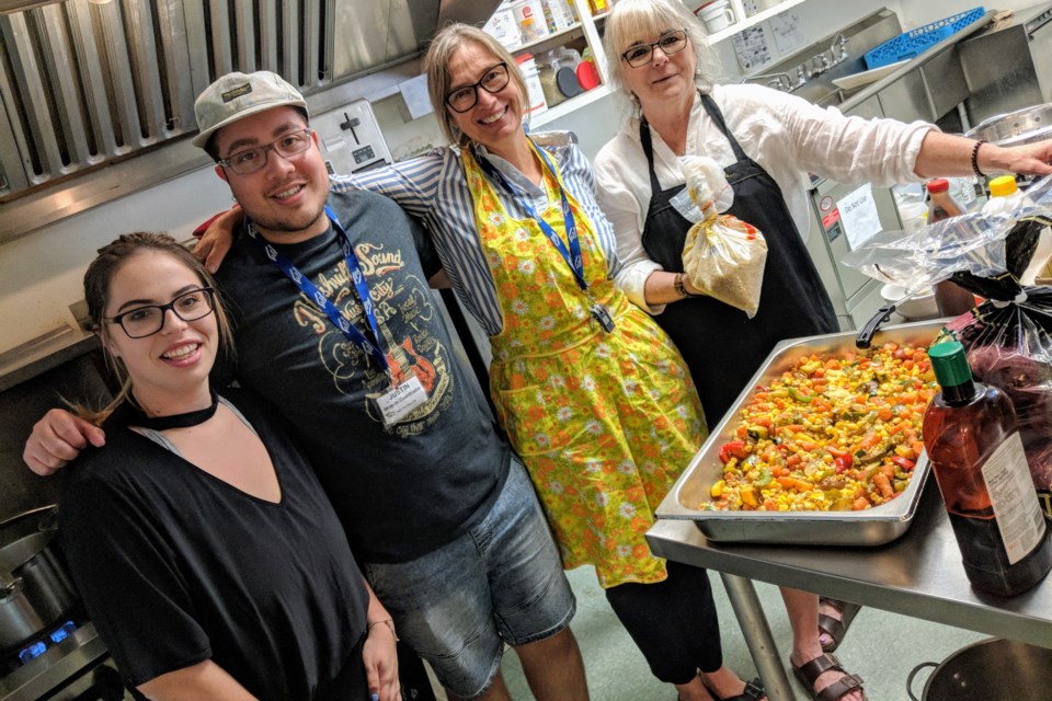 Inn from the Cold volunteers, along with executive director Ann Watson (third from left), work to prepare a meal for the drop-in program.