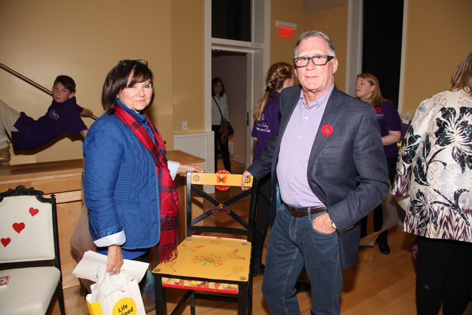 Kathy and Ian Proudfoot with the chair on which they successfully bid at the Empty Chair event in support of Oasis Centre for Bereavement and Healing Nov. 10 at the Old Town Hall.  Greg King for Newmarket Today
