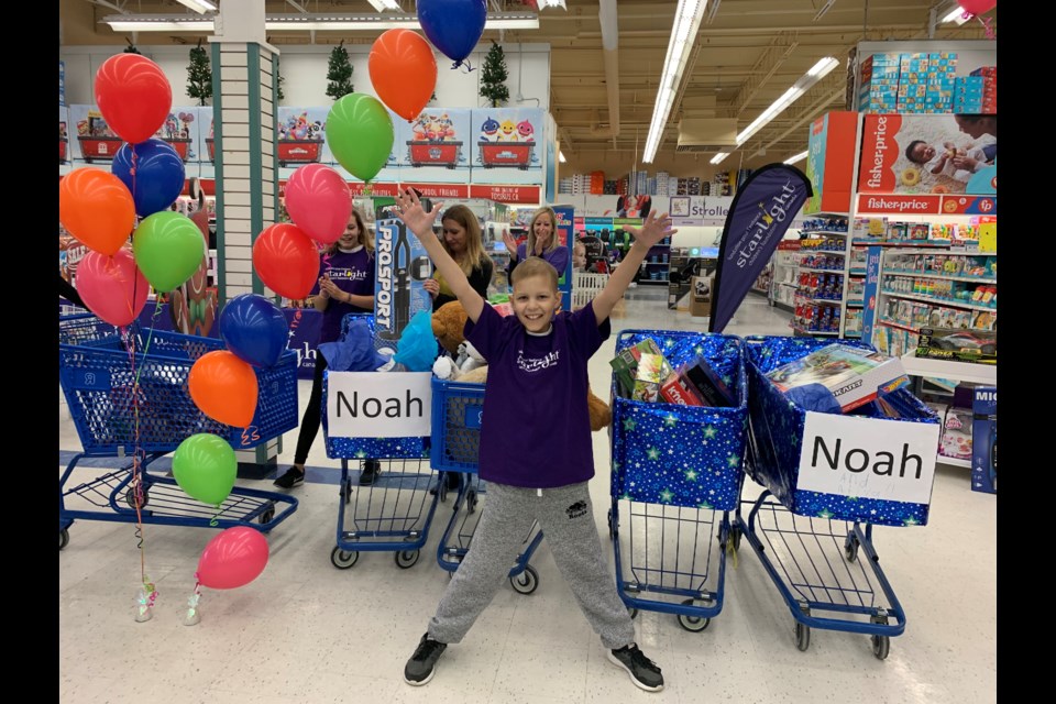 Noah, 9, celebrates a successful 3-Minute Dash, with five shopping carts brimming with toys, at Newmarket's Toys 'R' Us yesterday morning.  Debora Kelly/NewmarketToday