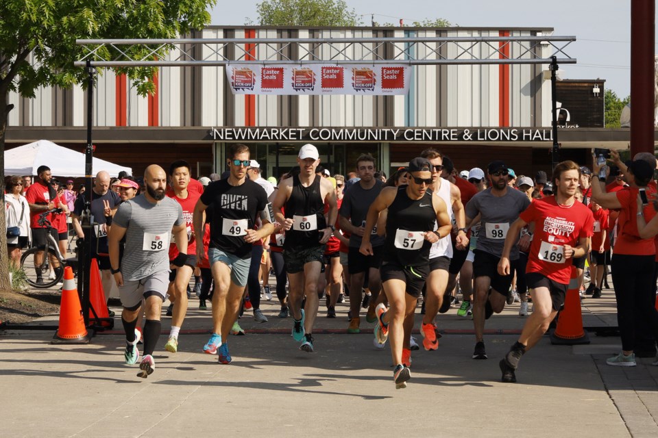 Runners take off from the starting line at Riverwalk Commons for the annual Easter Seals Run in Newmarket May 28. Participants raised thousands for the charity that helps those with disabilities.  Greg King for NewmarketToday