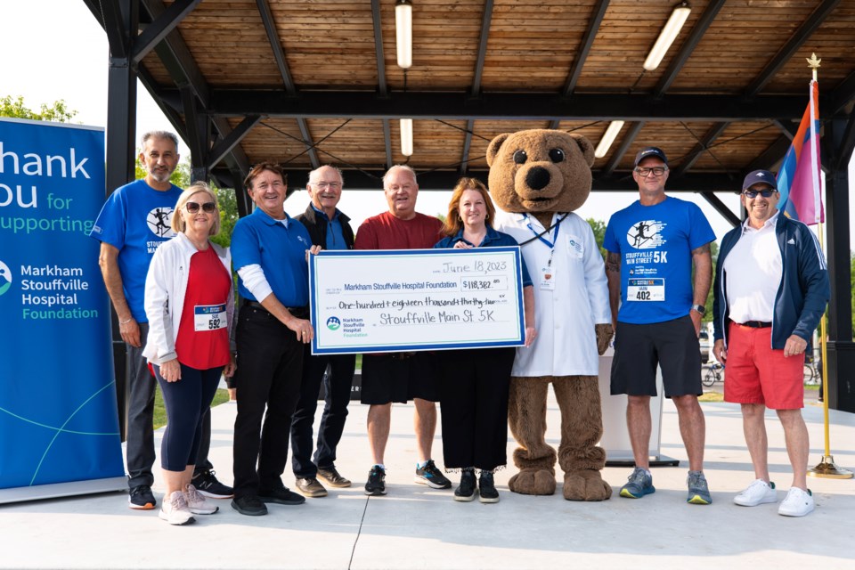 Stouffville Mayor Iain Lovatt and members of town council present Markham Stouffville Hospital Foundation officials with a cheque for more than $118,000, raised from the inaugural Stouffville Main Street 5K.