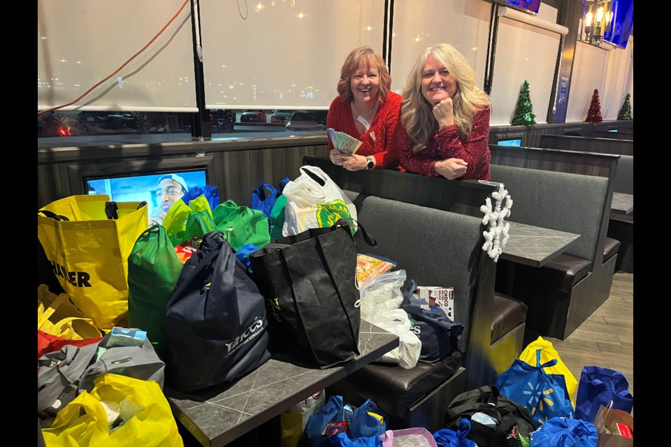 Patricia Hawke (left) organized the Ladies Supper Club holiday drive for the Newmarket Food Pantry, represented by board member Juliane Goyette, at Castle John's restaurant in Newmarket Dec. 10.