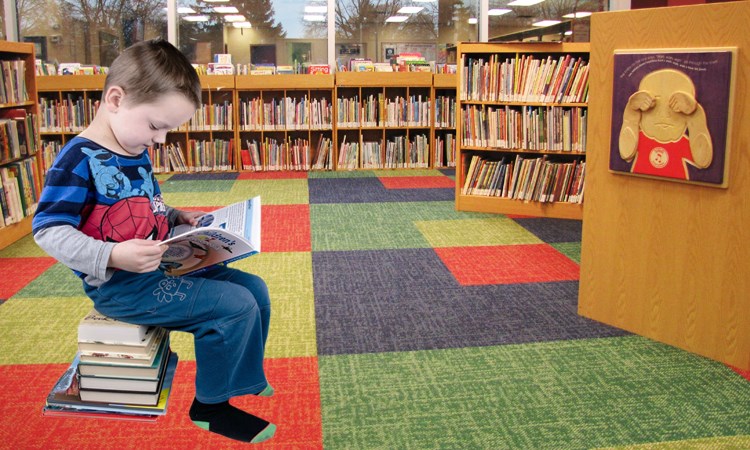 boy with books in children's department
