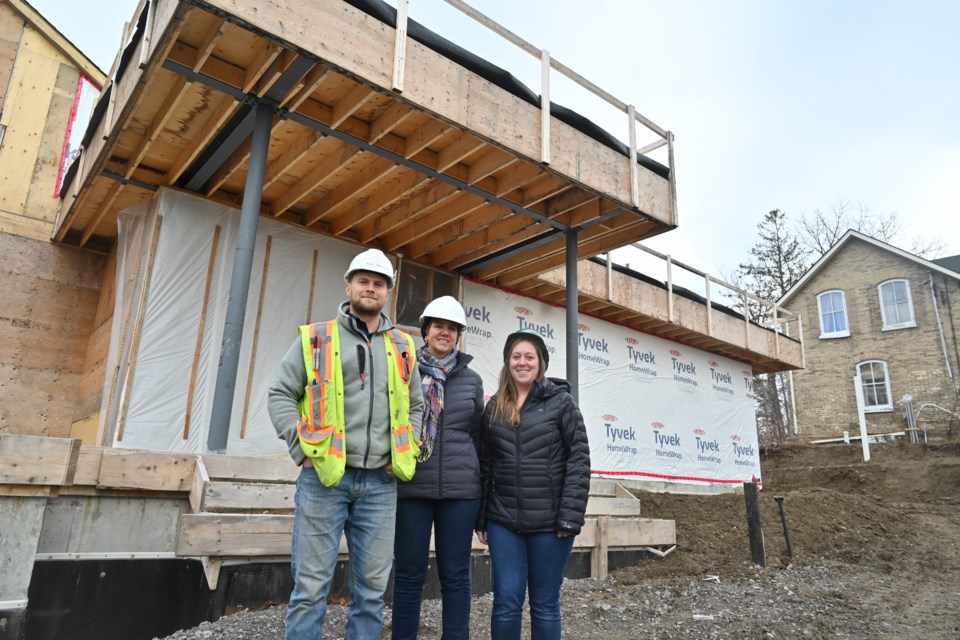 Construction manager Rick Gay, Denison Child Care Services executive director Nancy Mosey and educator Kristen Malecki stand outside the front doors to the future childcare facility on Fernbank Road.