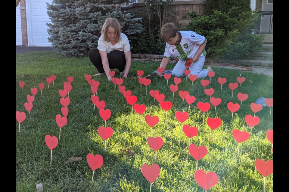 Caitlin and Adam plant hearts outside their Newmarket home in honour of the 215 children lost at a Kamloops residential school. 