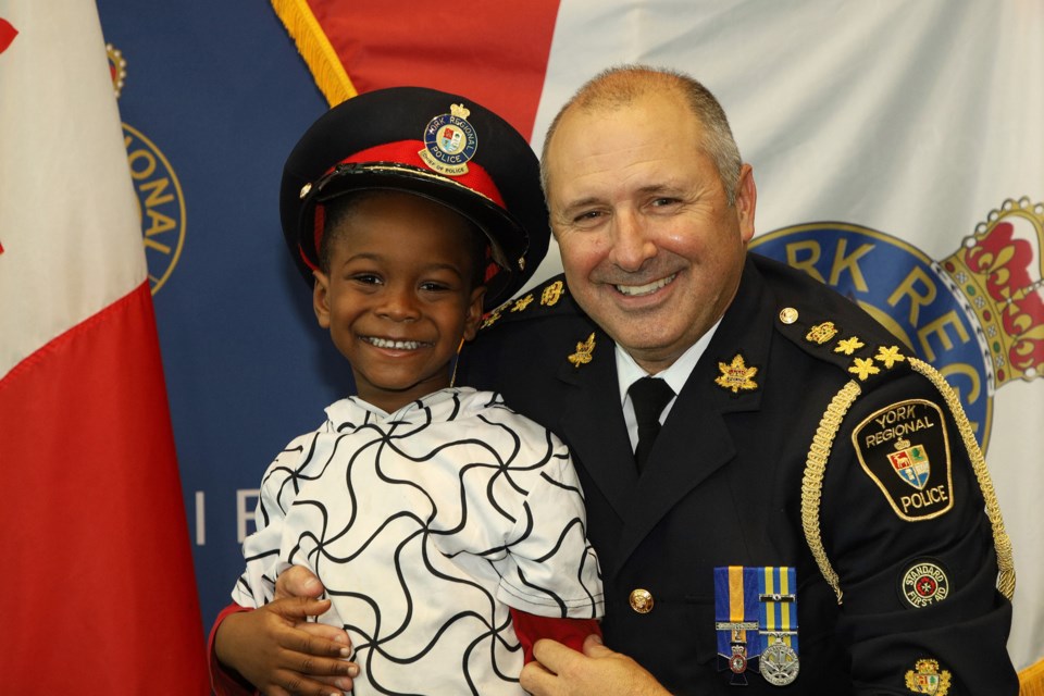 York Regional Police Chief Jim MacSween lets Kingsley Yirenkyi try on his hat at the force's Black History Month celebration Saturday, Feb. 11.  Greg King for NewmarketToday