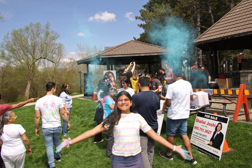 Swara Saindane tosses handfuls of blue powder into the air at the Holi celebration at Fairy Lake Park May 4 hosted by Newmarket's Samosa Master and the South Asian community.