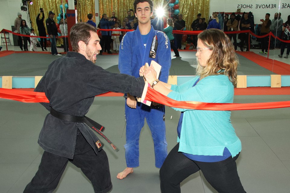 Sensei Rob Glick breaks the ceremonial board for the grand opening of Enlightened Martial Arts Academy in Newmarket.  Greg King for NewmarketToday