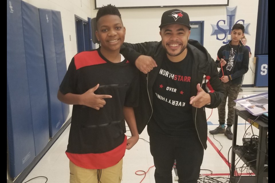 St. John Chrysostom CES student Malique welcomes rapper and author Duane D.O. Gibson, who visited the school today for Black History Month. Supplied photo/St. John Chrysostom CES 