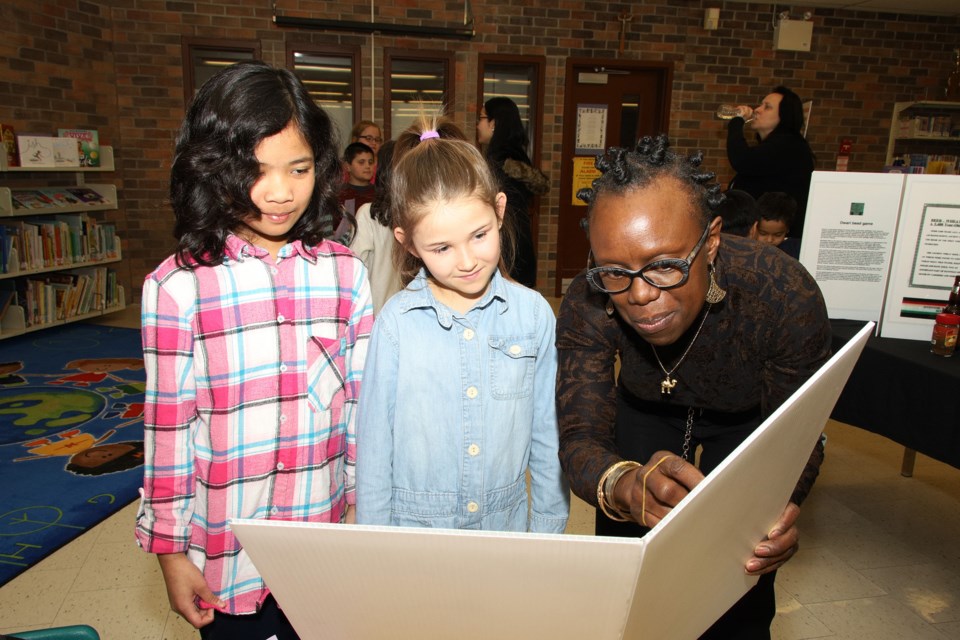 St. Paul Catholic Elementary School students Leanne Yago and Kaiya Burton listen as J. R. Dash of the Canadian Multicultural Inventors Museum describes a patent for a lemon squeezer.  Greg King for NewmarketToday