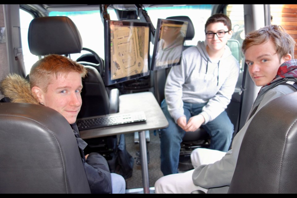 Sir William Mulock Grade 12 students Logan Williams (left) and Carson Brown (top right) and Milliken Mills High School Grade 12 student Christopher Lavoie check out the E-trek van. Debora Kelly/NewmarketToday                               