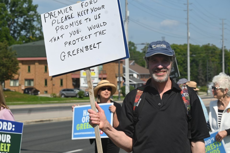 Paul Cottenden with a homemade sign at a Newmarket rally today protesting the Ontario government decision to open the Greenbelt to development.