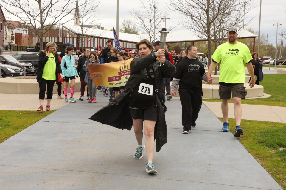 Special Olympics athletes carry the torch at Riverwalk Commons to begin the Race for Plunkett yesterday. Greg King for NewmarketToday