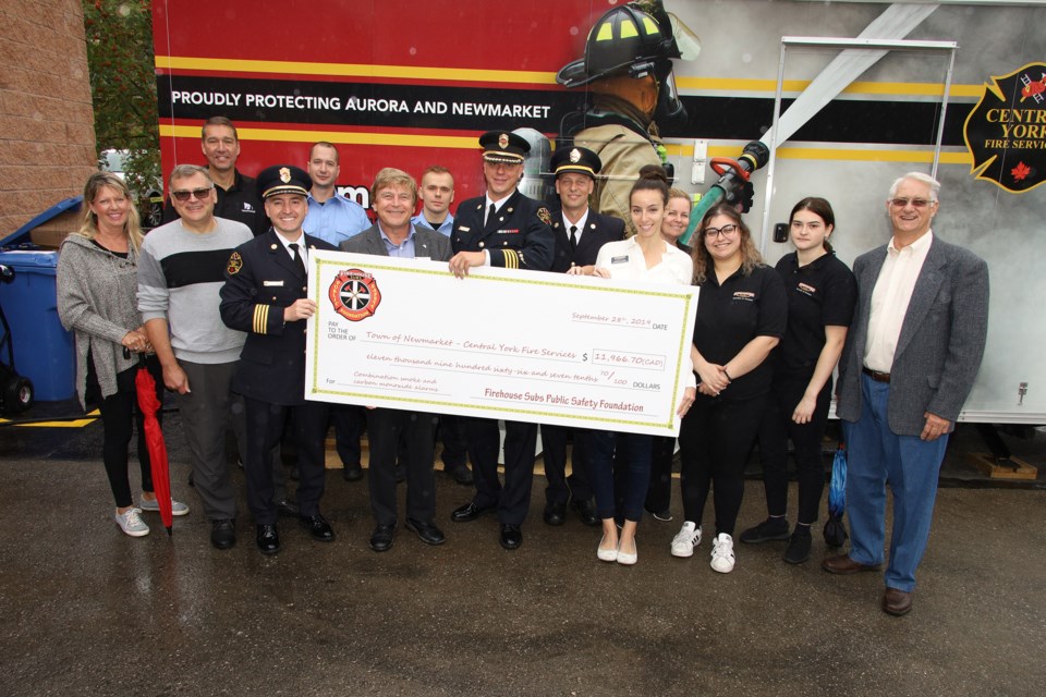 Members of Newmarket council and Central York Fire Services welcomed Firehouse Subs Public Safety Foundation of Canada's donation of $11,966, raised from customers rounding up their bills to the next dollar, to purchase carbon monoxide detector/smoke alarm units. Greg King for NewmarketToday