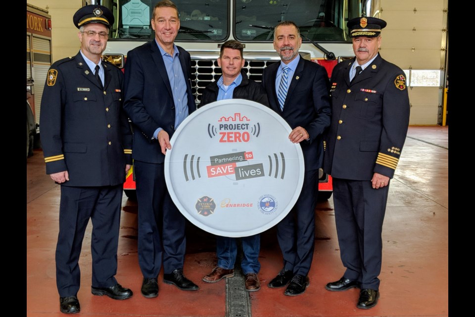 Central York Fire Services accepted a donation of 252 combination smoke and carbon monoxide alarms from Enbridge Gas, valued at just more than $15,000, at a Nov. 13 event at Newmarket's Gorham Street fire hall 4-1. Shown here (from left) are Rick Finnemore, a fire protection adviser from the Office of the Fire Marshal and Emergency Management, Newmarket Mayor John Taylor, Enbridge Gas regional construction manager Jason McArthur, Aurora Mayor Tom Mrakas, and CYFS Fire Chief Ian Laing. Kim Champion/NewmarketToday