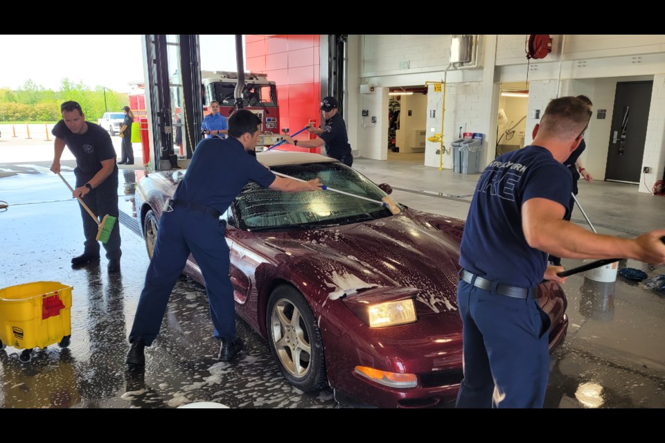 Volunteers carefully clean a Corvette at CYFS charity car wash in support of United Way. 