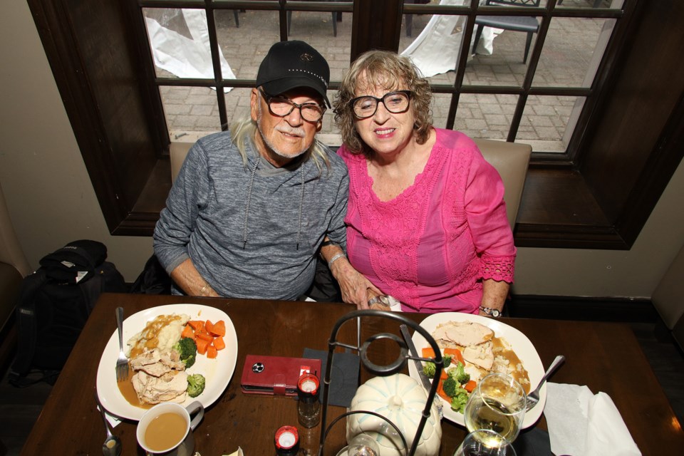 Bill Baker and Cynthia Roberts enjoy their turkey dinner at the third annual Cachet Restuarant community Thanksgiving dinner Monday.  Greg King for NewmarketToday