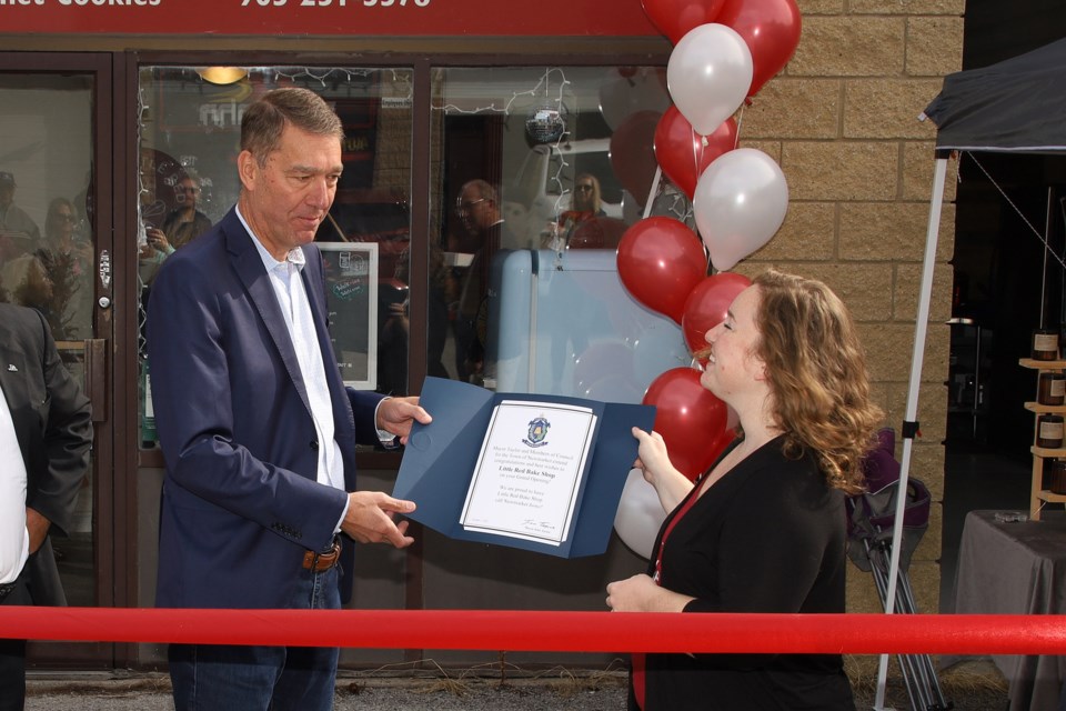 Newmarket Mayor John Taylor presents The Little Red Bake Shop owner Michelle Bullen with a letter from council congratulating her on her new business.  Greg King for NewmarketToday