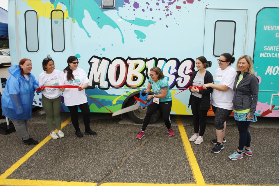 CMHA-YRSS CEO Rebecca Shields, with her team, cuts the ribbon to officially open the new MOBYSS bus, a mobile clinic for youth at Mental Health in Motion June 11.  Greg King for NewmarketToday