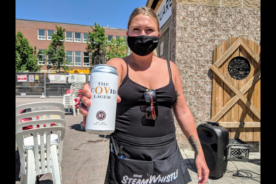 Olde Village Free House server Hannah Kavanagh shows the pub's signature suds, The cOVid Lager, brewed in partnership with Newmarket's Red Thread Brewing. A portion of the proceeds goes to Southlake Regional Health Centre. Kim Champion/NewmarketToday