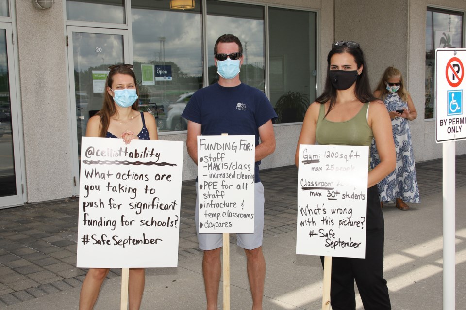 Lindsay Nolan, Gared Johnson, and Roxana Caraiani are concerned parents who joined a protest at Newmarket-Aurora MPP Christine Elliott's office today.  Greg King for NewmarketToday
