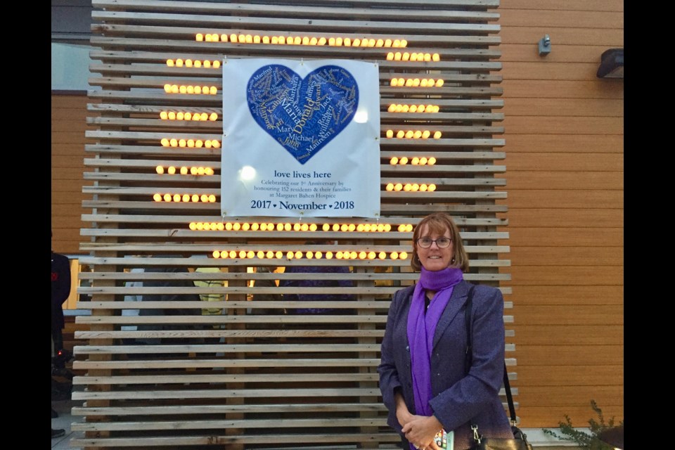 Susan Chant, daughter of the late Margaret Bahen, stands before the   152 candles lit for Margaret Bahen Hospice residents during its first year. Debora Kelly/NewmarketToday 