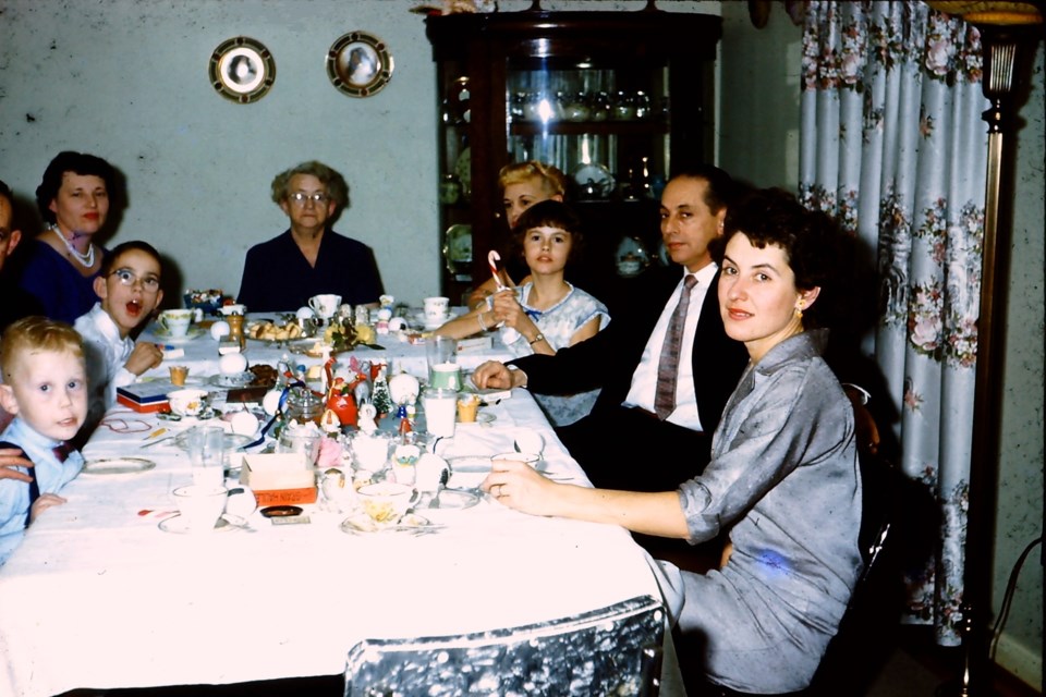 Family gathers for Christmas dinner in the early 1960s.