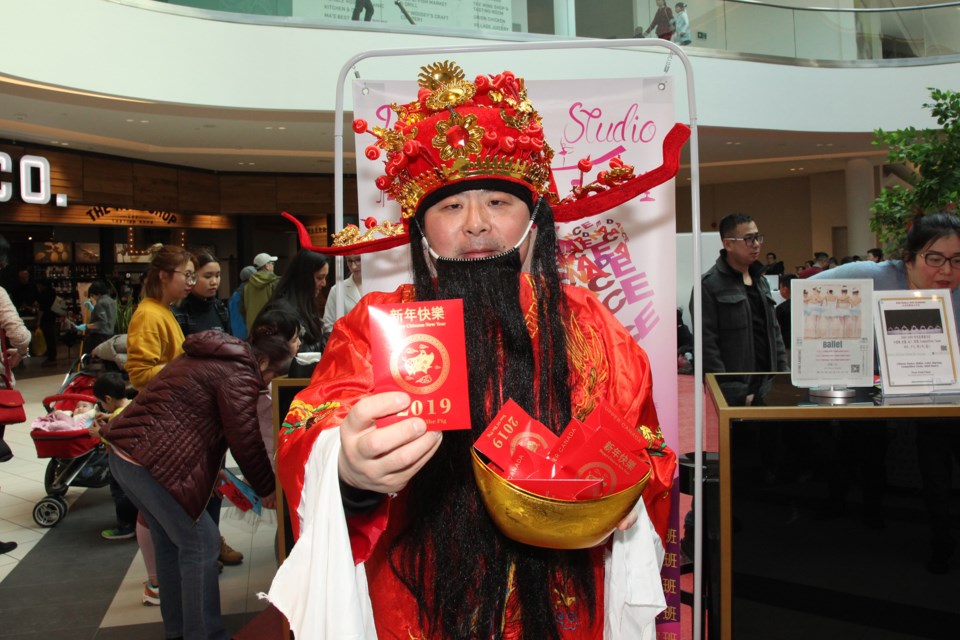 The God of Fortune hands out the traditional red envelopes of lucky money at the Northern Toronto Lunar New Year Celebration at Upper Canada Mall yesterday.  Greg King for NewmarketToday