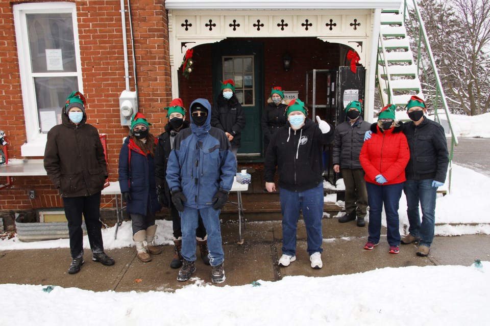 Pastor Andrew Hamilton, here with a thumb's up, and volunteers from the Christian Baptist Church on Newmarket's Main Street expanded their Porch Pantry Mission Dec. 26 by providing 70 free meals and gifts to the town's homeless and anyone in need.  Greg King for NewmarketToday