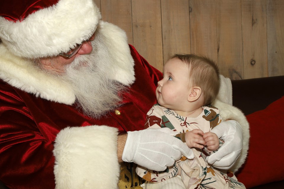 Olivia Huntley takes a good look at Santa and his big beard while visiting the Holly Jolly Lodge at Upper Canada Mall in Newmarket.