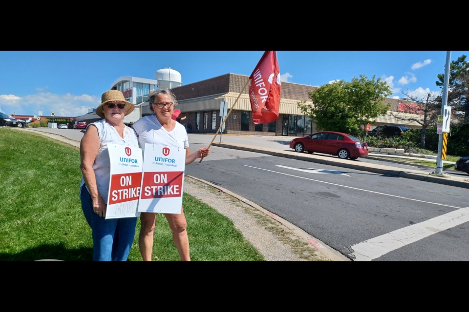 Davis Drive Metro workers Brenda Megill and Teresa Patano seek support at the corner outside their workplace.