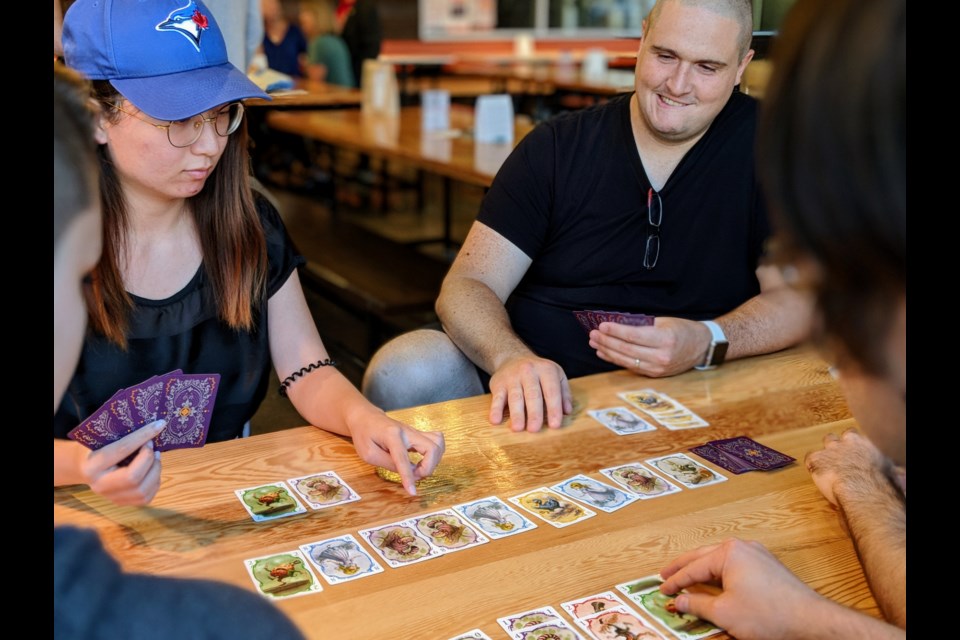 Newmarket Board Gamers founder Mike Barnett plays Parade with members, including Rosa Luo.