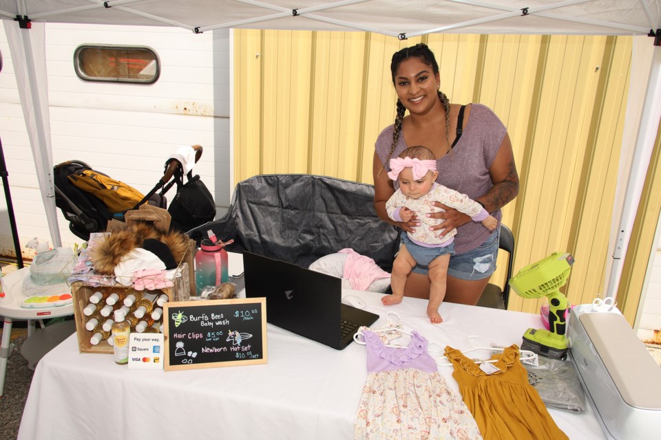 Ashlee Ramsumeer's daughter, Ava, models the baby clothes that she makes at the first Makers Festival July 23 hosted by NewMakeIt.  Greg King for NewmarketToday