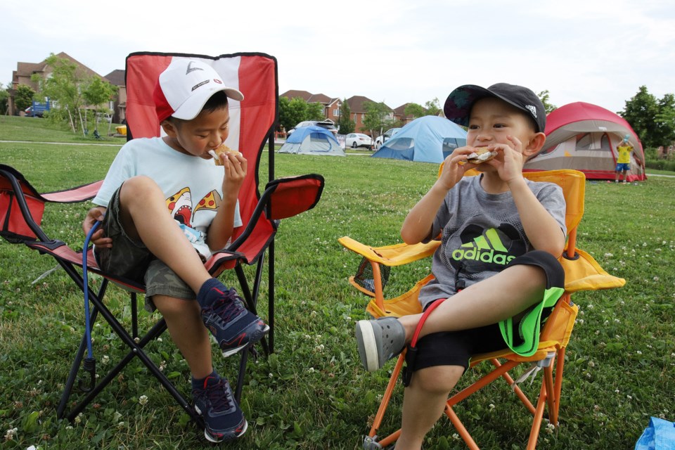Jeremy and Daniel Lin love s'mores at the summer family campout at the Environmental Park yesterday.  Greg King for NewmarketToday