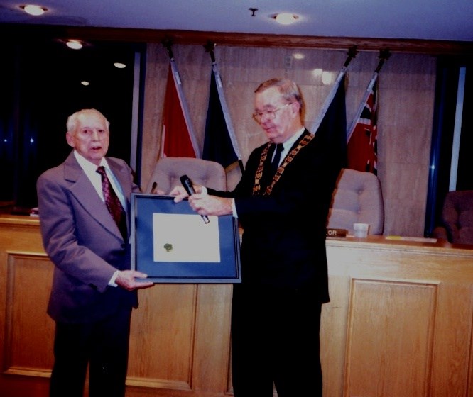 George Luesby receives the Citizen of the Year Award from then mayor Tom Taylor.