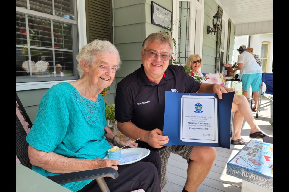 Maureen Huismans with Newmarket Councillor Bob Kwapis, in August 2021, holding a certificate commemorating her 90th birthday. 