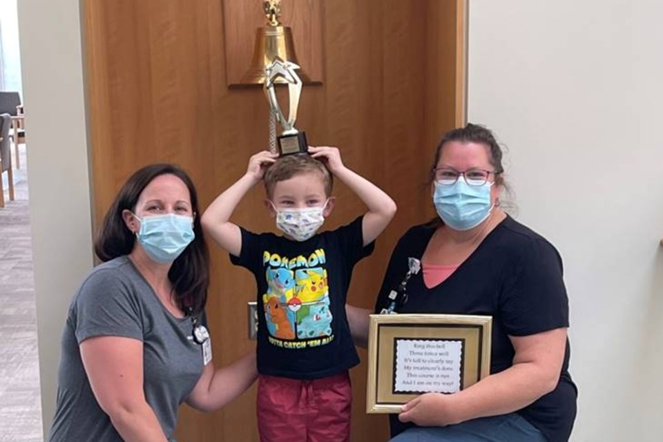 Atticus D'Orazio ringing the Be a Hero bell with his pediatric oncology registered nurses (from left) Jennifer Barbeau and Lisa Egan-Bates.