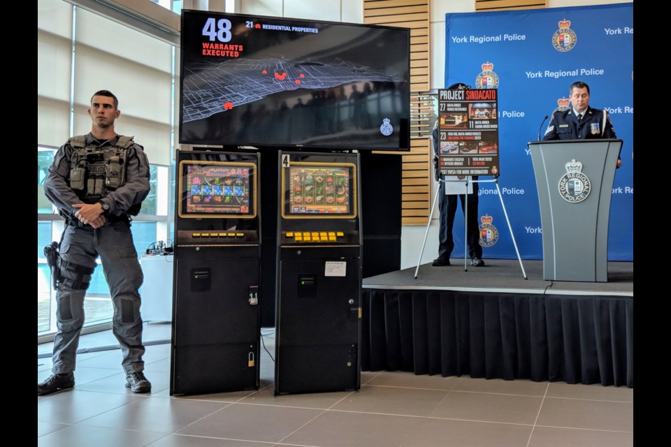 A York Regional Police tactical officer stands beside video gaming machines seized in the Figliomeni crime family bust. Kim Champion/NewmarketToday