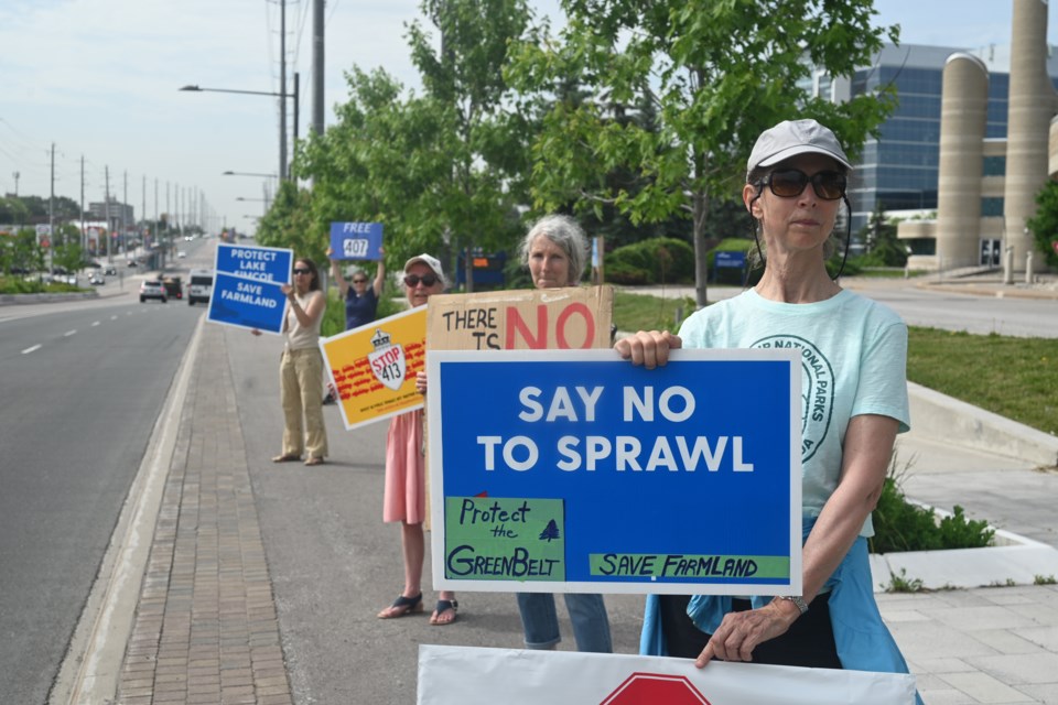 Protestors wave signs along Yonge Street against the York Region official plan. From front, Cathy Wellesley, Alexandra, Sherry Draisey, Susan Sheard, Irene Ford.