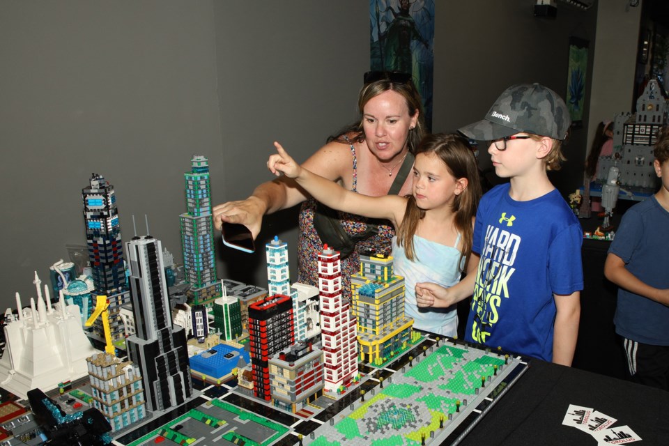Ashley Csinos and her kids, Leah and Tyler, admire the LEGO downtown at the Toronto & GTA LEGO Users Group show hosted by Goblets & Goblins board game cafe on Main Street Newmarket Sunday, June 26. Greg King for NewmarketToday