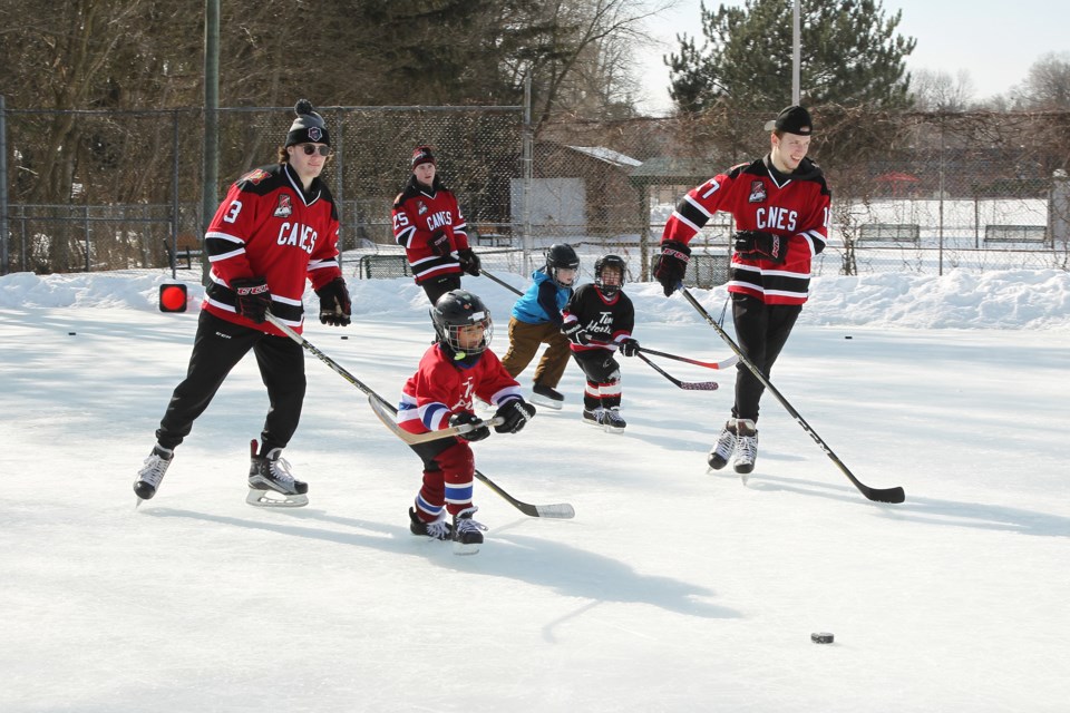 Conor Howie, Braydon Johnston, and Donny Van Decker play a little 3 on 3 with Riley Valade (3), Klim Georgiev (17), and Josh Faussett (25) at the Lions Park Community Rink Feb. 23.  Greg King for NewmarketToday