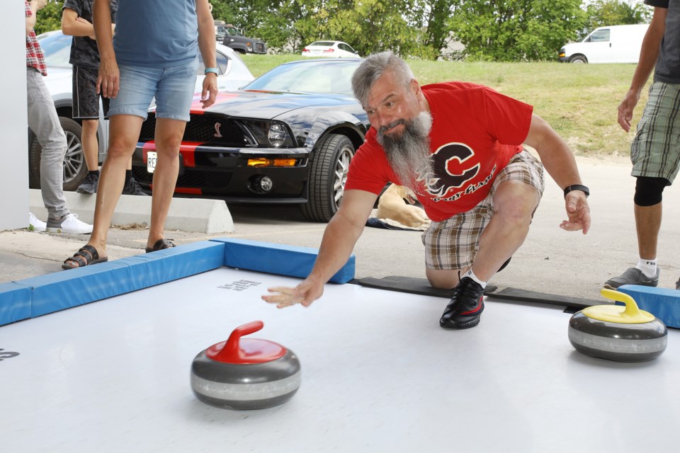 Richmond Hill Curling Club manager Vito Lozer throws a stone at the York Curling Club's street curling event yesterday at Market Brewing Co.  Greg King for NewmarketToday