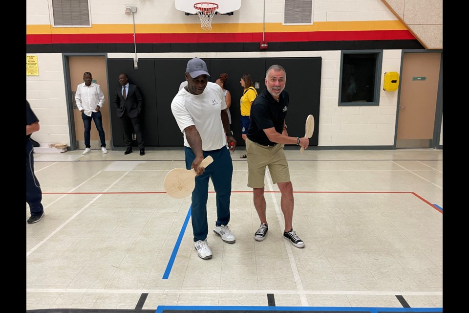 Former professional tennis player Lionel Eli and Aurora Mayor Tom Mrakas get ready to have some fun on the road tennis court at Wednesday's launch event.