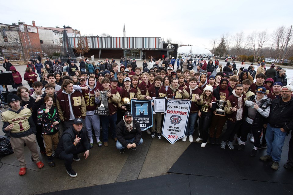 Huron Heights' junior and senior Warriors teams pose with their trophies and pennants on Warriors Day, Dec. 9, at Riverwalk Commons in downtown Newmarket.