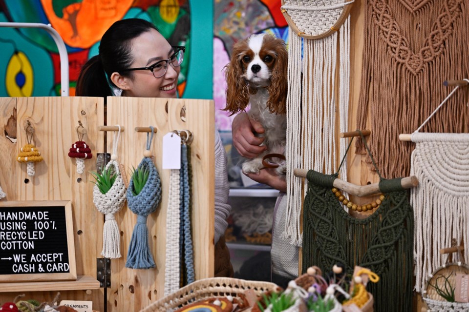 Aayla, a Cavalier King Charles Spaniel, peers out from the the ‘I Literally Can Knot’ booth at the New West Craft Holiday Night Market.