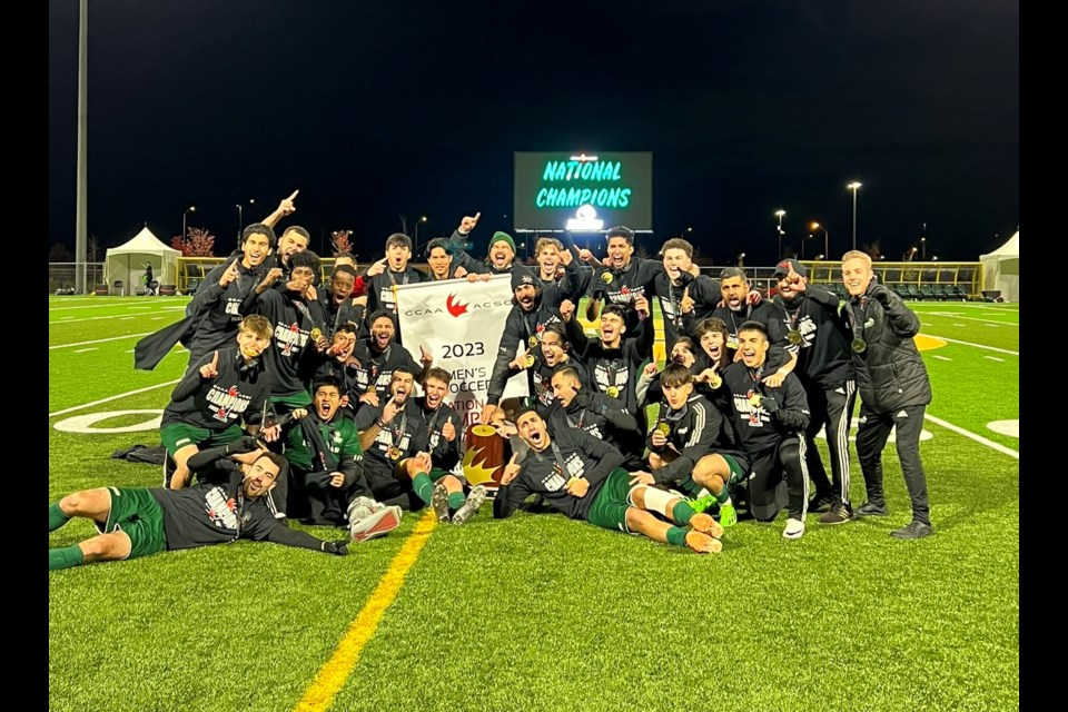 The Douglas College Royals, based in New Westminster, pose with the CCAA championship trophy and banner — their second national title in program history — after winning the tournament in Windsor, Ont., on Nov. 11, 2023.