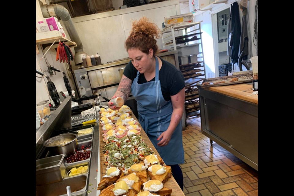Angela Caputo prepares a line of eggs benedict in her kitchen at The Breakfast Pig. (Supplied)