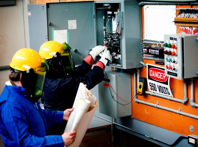 electrical engineering technology students are doing live voltage testing on a combination starter